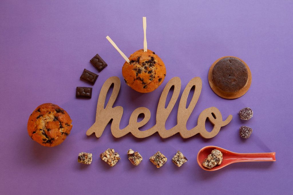 Le texte hello écrit sur un fond violet avec du chocolat et des cookies