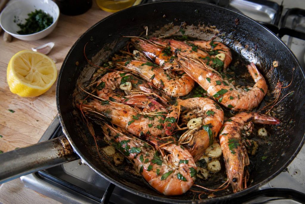Un poêle avec des gambas cuites